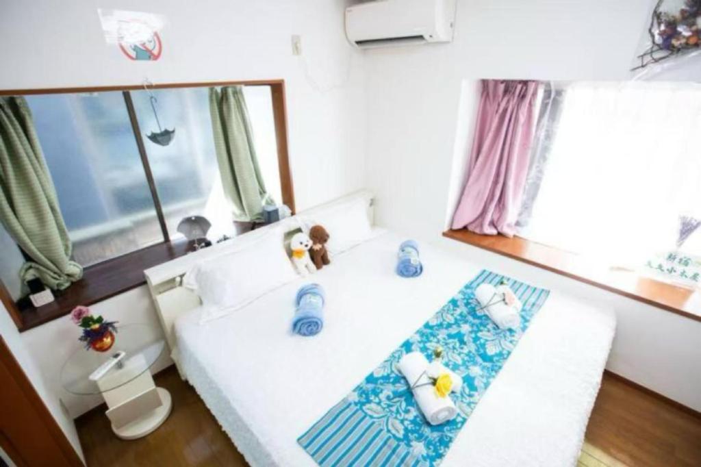 a small bedroom with a white bed with blue accents at 新宿久久小木屋 整栋出租 in Tokyo