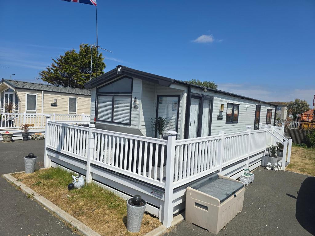a mobile home with a white railing and a porch at Lyons robin hood HV in Meliden