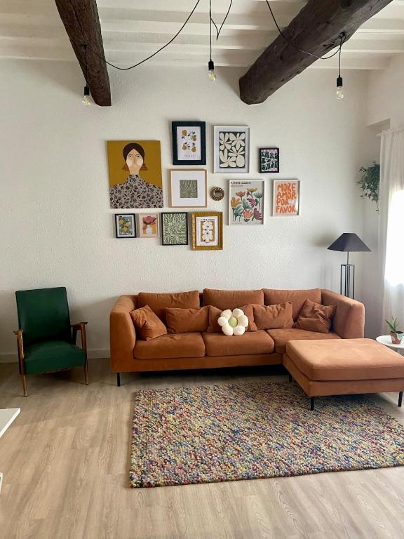 d'un salon avec un canapé marron et des photos murales. dans l'établissement Mauguio Arty Cosy Wifi Netflix AC, à Mauguio