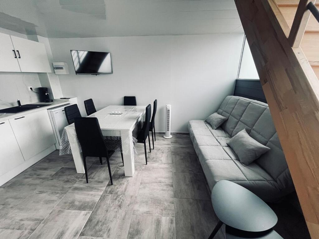 un salon avec un canapé et une table avec des chaises dans l'établissement Studio tout neuf à Canet plage, à Canet