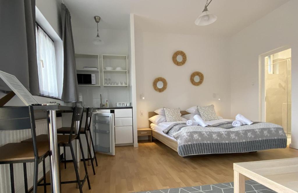 a bedroom with a bed and a desk and a kitchen at Malom-tó Vendégház Tapolca in Tapolca