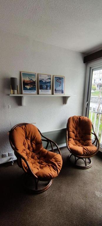 deux chaises assises dans une pièce avec une fenêtre dans l'établissement Résidence Ayre - Spacieux T2 proche du centre de Barèges MAE-1601, à Barèges