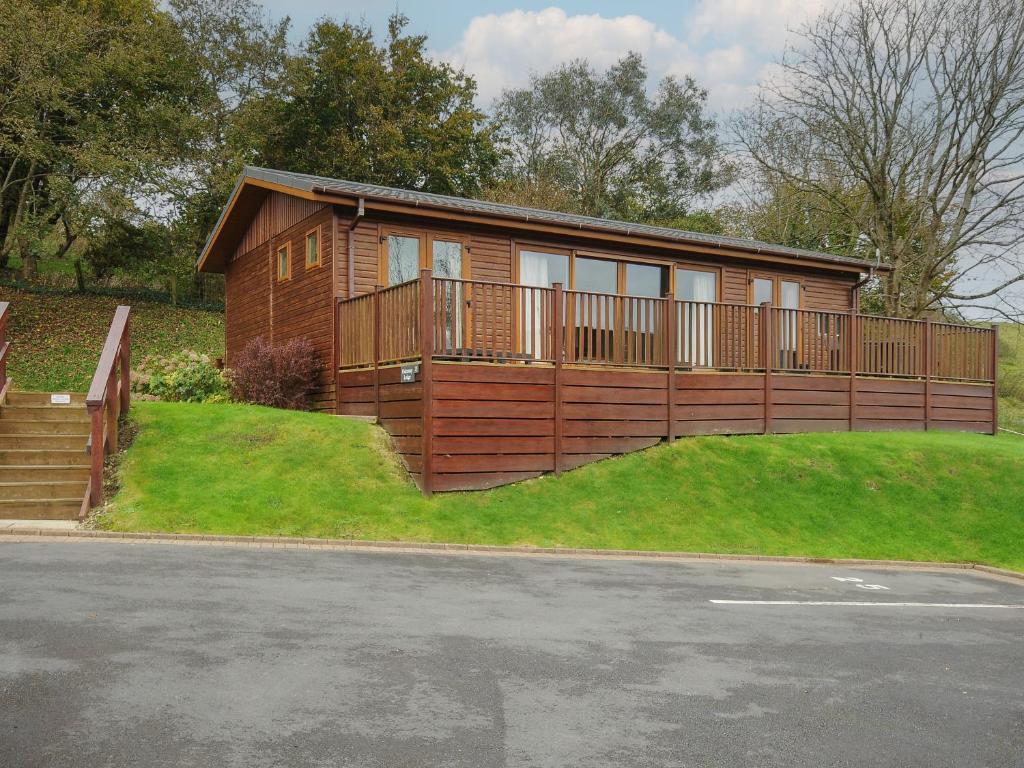 a home with a wooden fence and a house at Hideaway Lodge in Tintagel