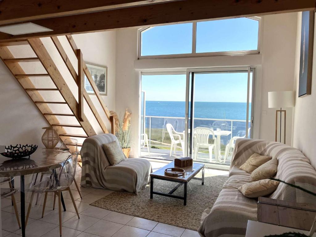 un salon avec un canapé et une vue sur l'océan dans l'établissement Langoustine Saint Hilaire de Riez, à Saint-Hilaire-de-Riez