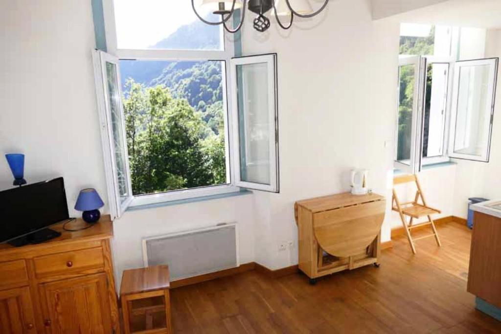 a living room with three windows and a television at Résidence Helios - Studio cabine avec garage vue sur la montagne MAE-0893 in Barèges