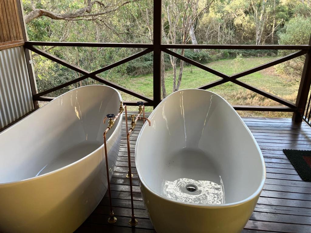 una vasca da bagno bianca seduta di fronte a una finestra di Balingup Jalbrook Cottages Jalbrook Estate a Balingup