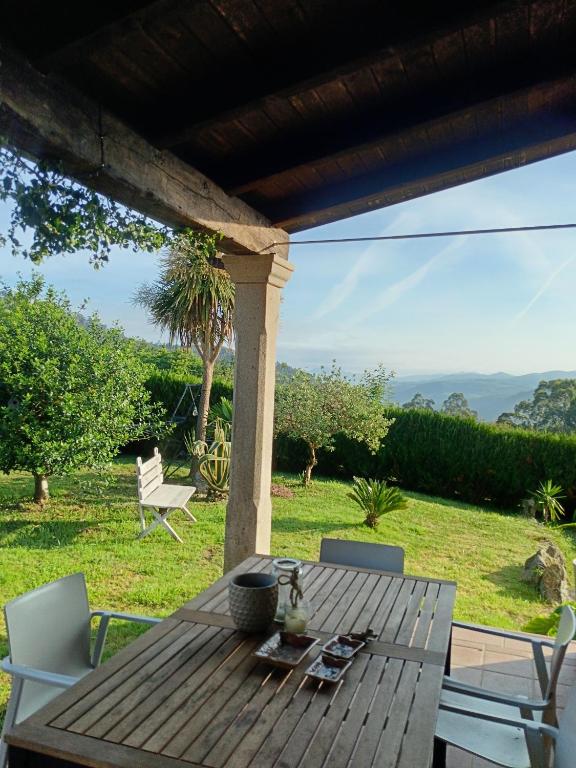 ein Holztisch und Stühle auf einer Terrasse in der Unterkunft A Mouta in Amoedo