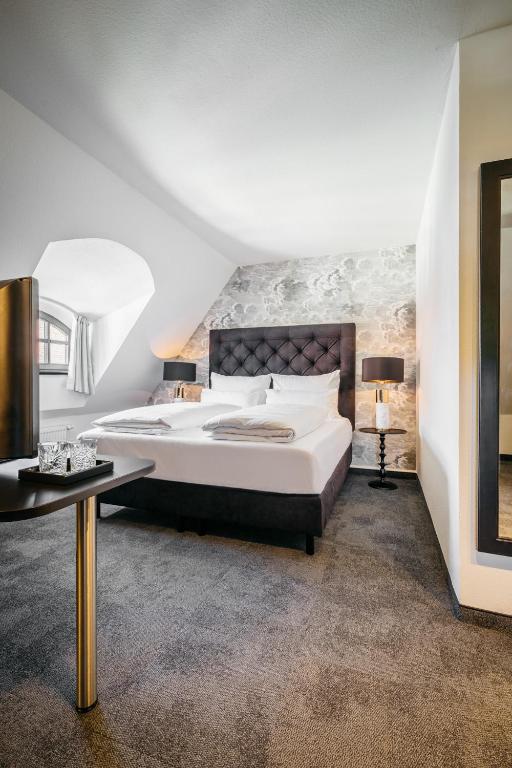 ein Schlafzimmer mit einem großen Bett und einem Tisch in der Unterkunft Hotel Riesengebirge in Neuhof an der Zenn