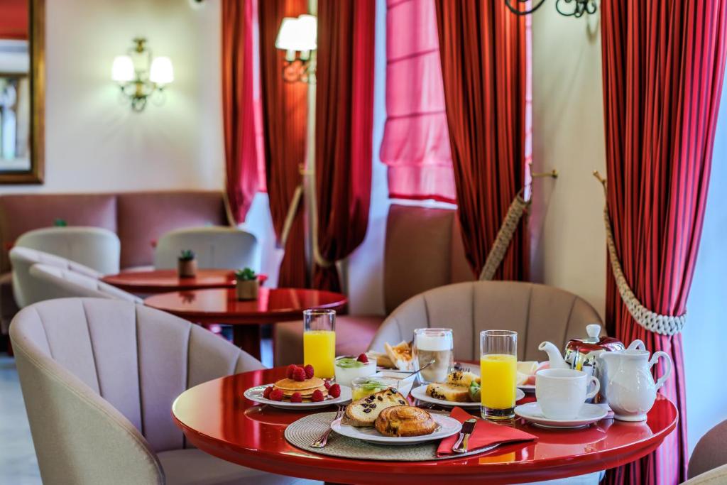 a table with plates of food and orange juice at Le Cavendish in Cannes