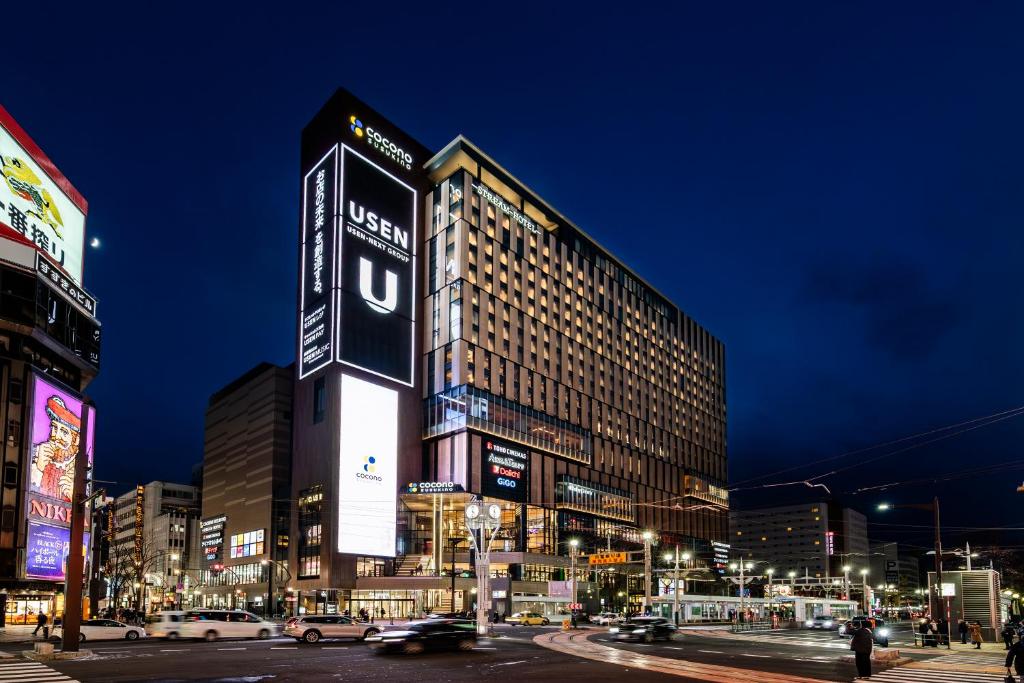 札幌SAPPORO STREAM HOTEL的夜晚城市中的一座大楼