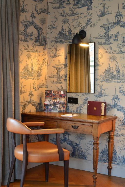 a desk with a chair and a mirror on a wall at Monbijou Hotel in Berlin