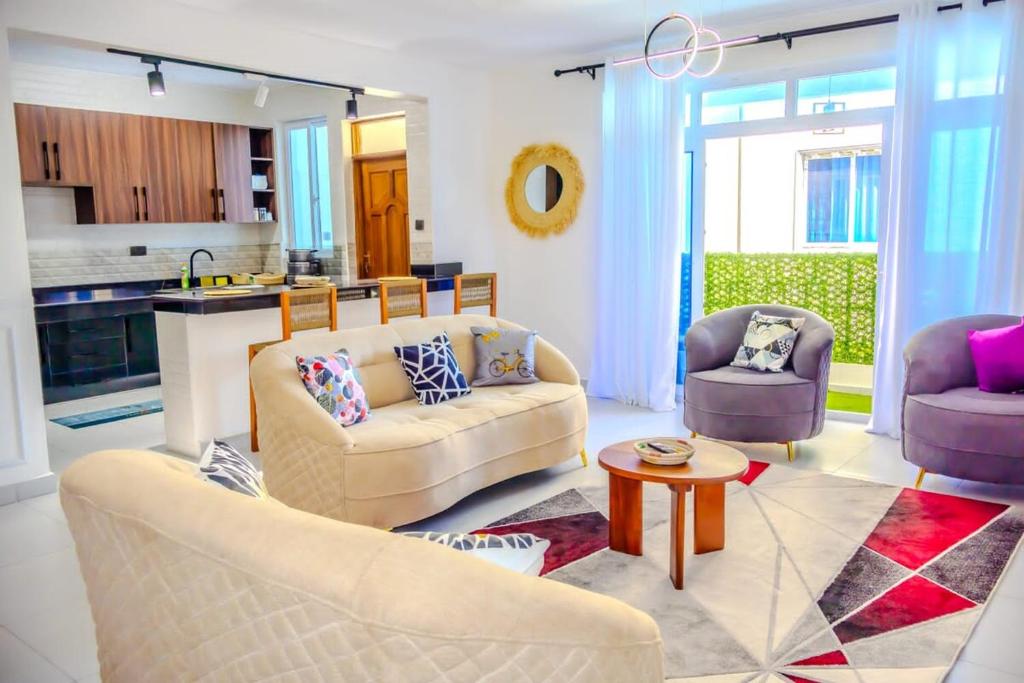 a living room with two couches and a table at Coastal 3BR Vibe, GEM in Nyali in Mombasa