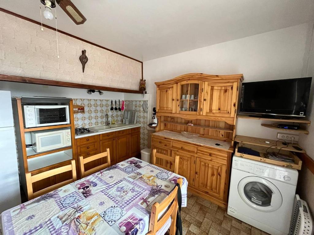 une cuisine avec une table et une machine à laver dans l'établissement Corvette Appartement, à Saint Pierre La Mer