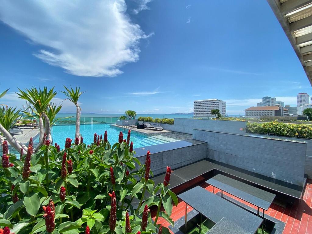 a view of a pool from a building with red flowers at The Gallery Condominium M in Jomtien Beach