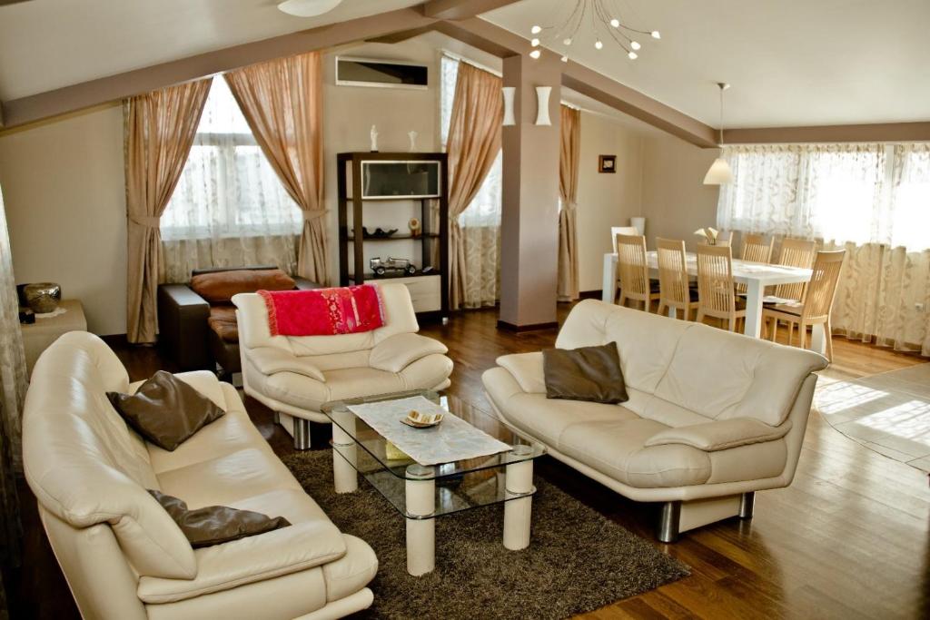a living room with white chairs and a table at Apartment St James in Međugorje