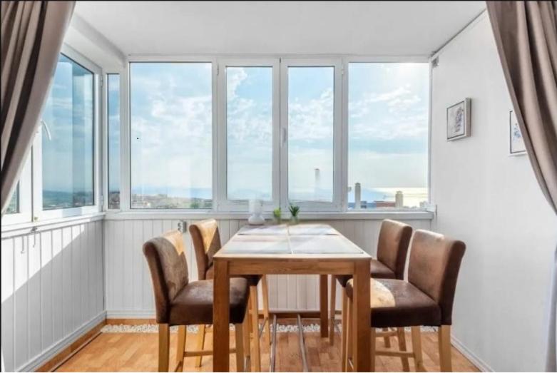 a dining room with a table and chairs and windows at Torreblanca E&S in Torrevieja