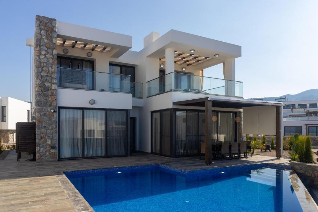 a house with a swimming pool in front of it at Villa Deja Blu with Private Pool in Kalogrea