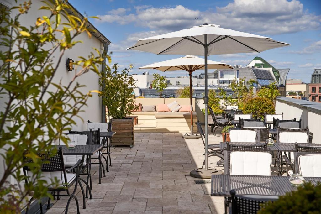 a patio with tables and chairs and an umbrella at Monbijou Hotel in Berlin