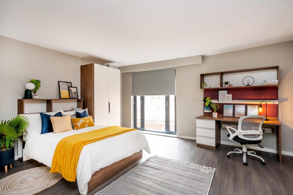 a bedroom with a bed and a desk and a chair at Inspiring Spaces at Zinc Works in Bristol