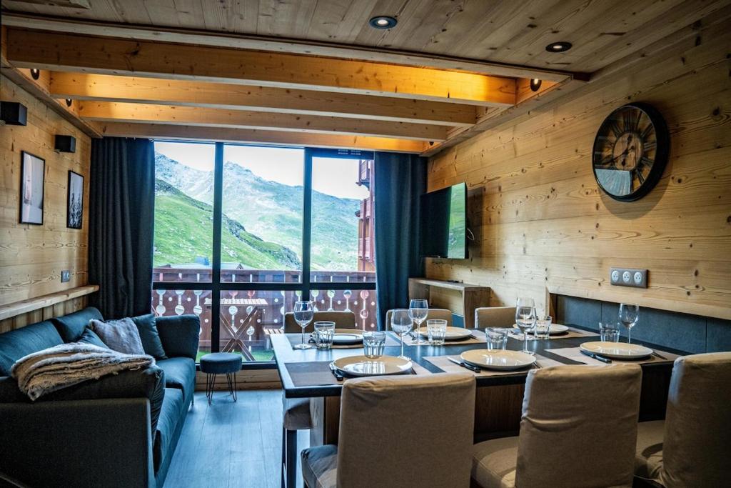 un restaurant avec une table, des chaises et une grande fenêtre dans l'établissement Silveralp Cosy Apartment 6 people, à Val Thorens