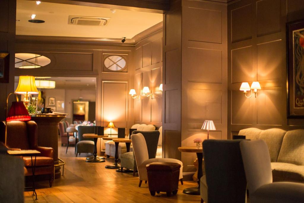 a waiting room with chairs and tables and lights at Monbijou Hotel in Berlin