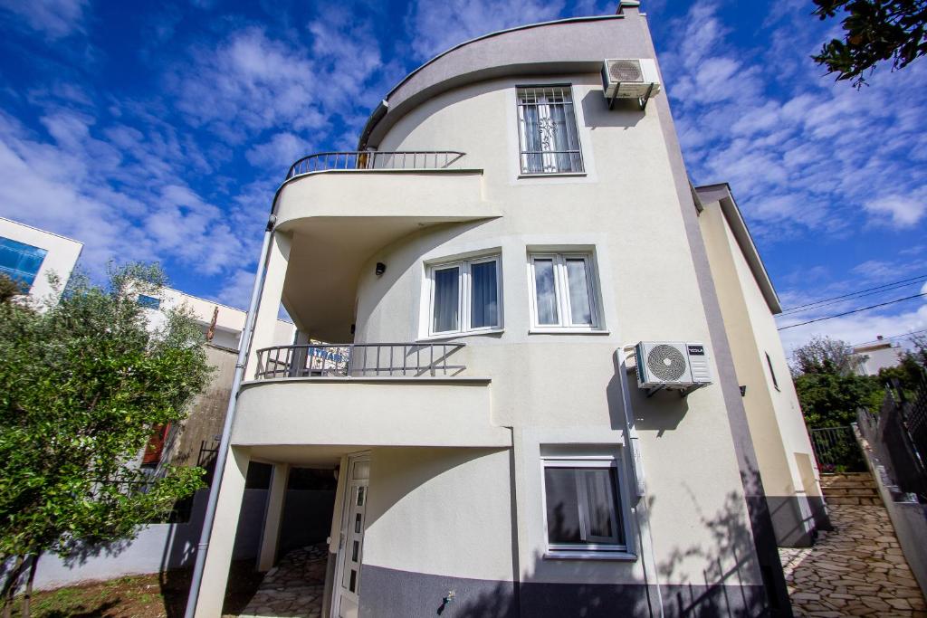 a white building with a balcony on the side of it at Oliva home in Utjeha