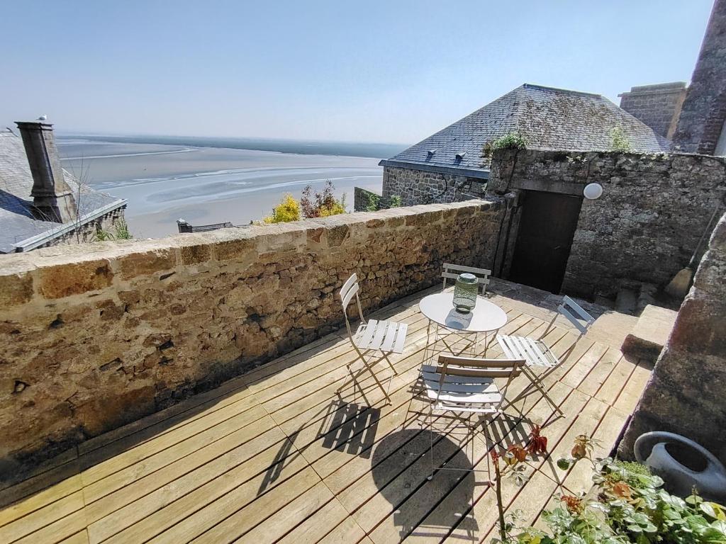 a patio with a table and chairs on a balcony at Chez Adèle in Le Mont Saint Michel