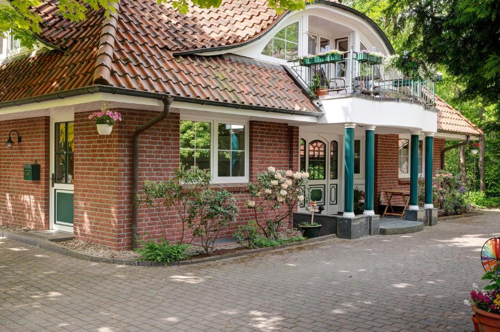 a red brick house with a balcony at Ferienhaus im Grünen in Harsefeld