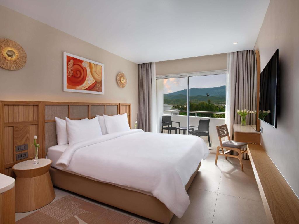 a hotel room with a large bed and a window at Rixos Premium Tekirova - The Land of Legends Access in Tekirova