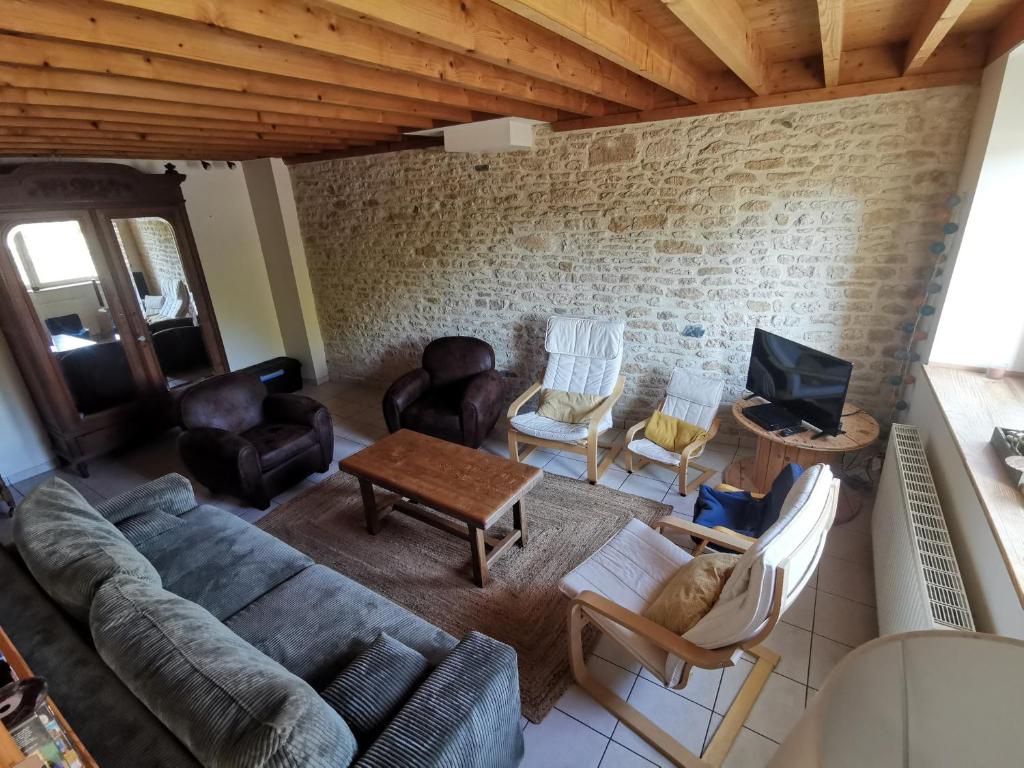 salon z kanapą, krzesłami i telewizorem w obiekcie La Grange - Charmante maison à Langrune-sur-mer w mieście Langrune-sur-Mer