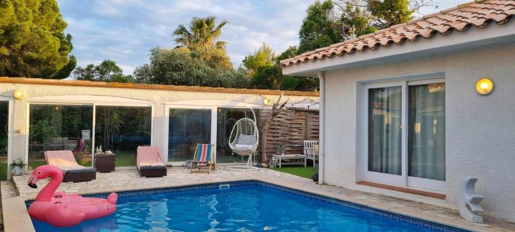 - une piscine avec un flamingo rose dans une maison dans l'établissement La Villa Azul, à Saint-Laurent-de-la-Salanque