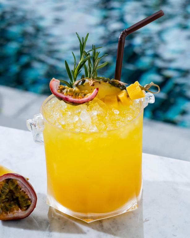 A bright pineapple and passion-fruit drink served beside the pool.