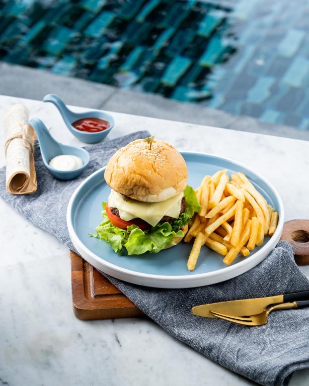 A burger and fries served on a poolside table.