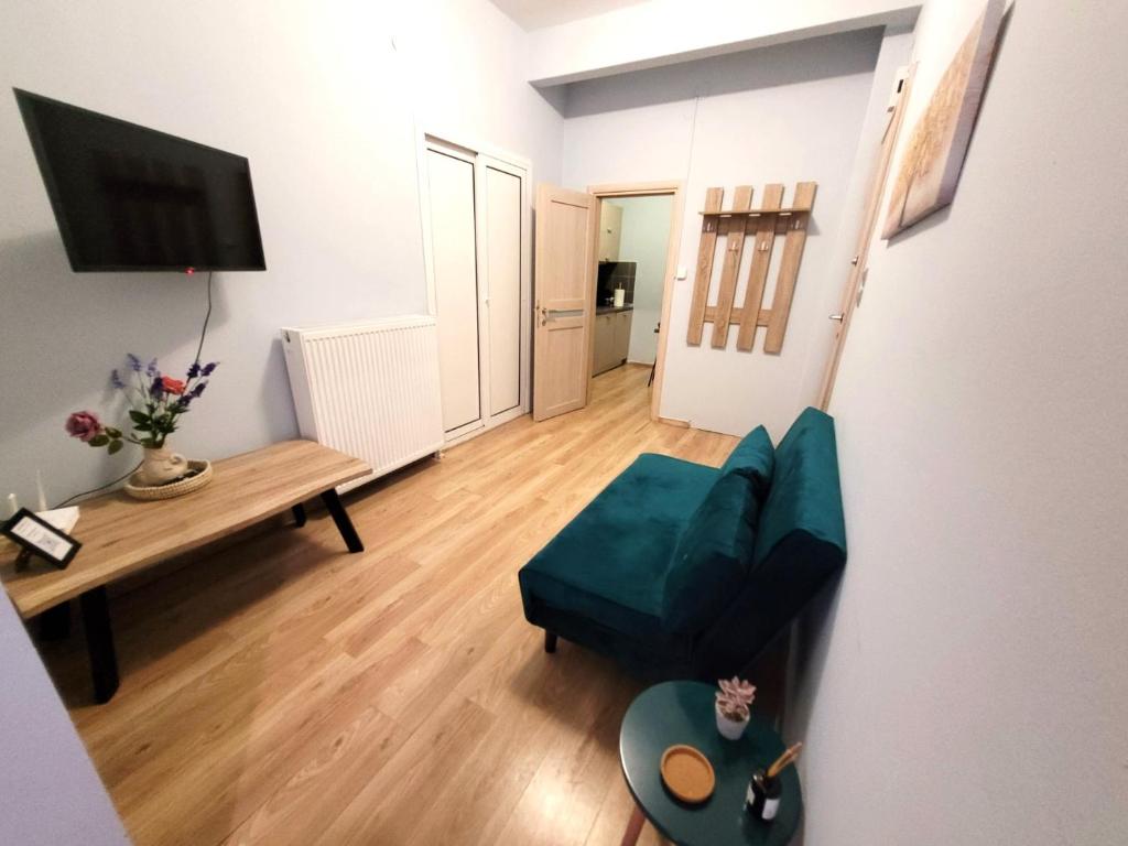 a living room with a couch and a television at Metropole Vibe by GOLDENLAND in Thessaloniki