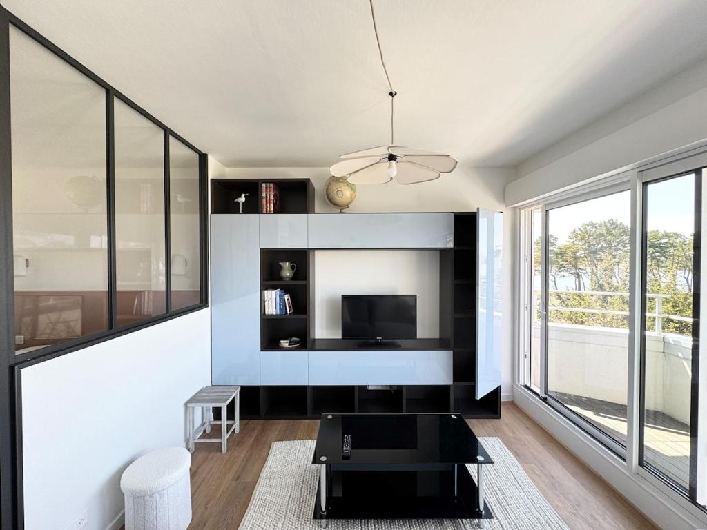 un salon avec une télévision et une table dans l'établissement Appartement rénové vue mer, Bénodet, à Bénodet