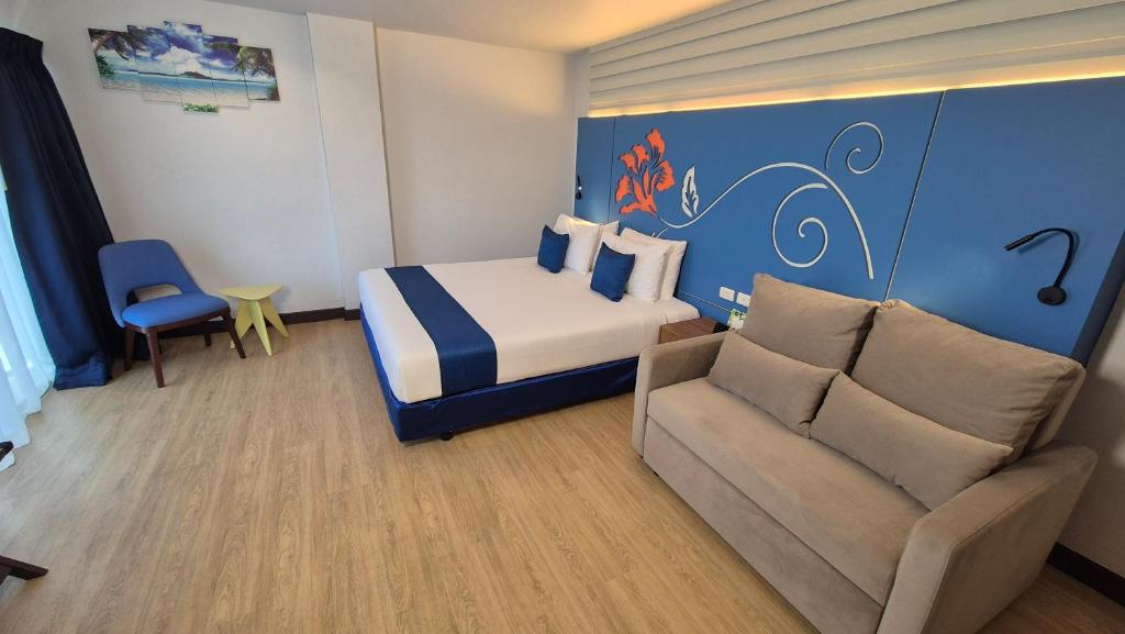 a hotel room with a bed and a couch at Days Inn by Wyndham Patong Beach in Patong Beach
