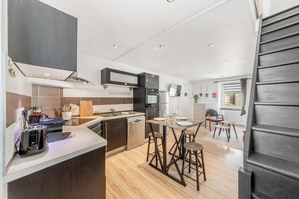 une cuisine avec une table et quelques chaises dans l'établissement L'Amadea - Duplex - 3 pers au coeur de Parame, à Saint-Malo