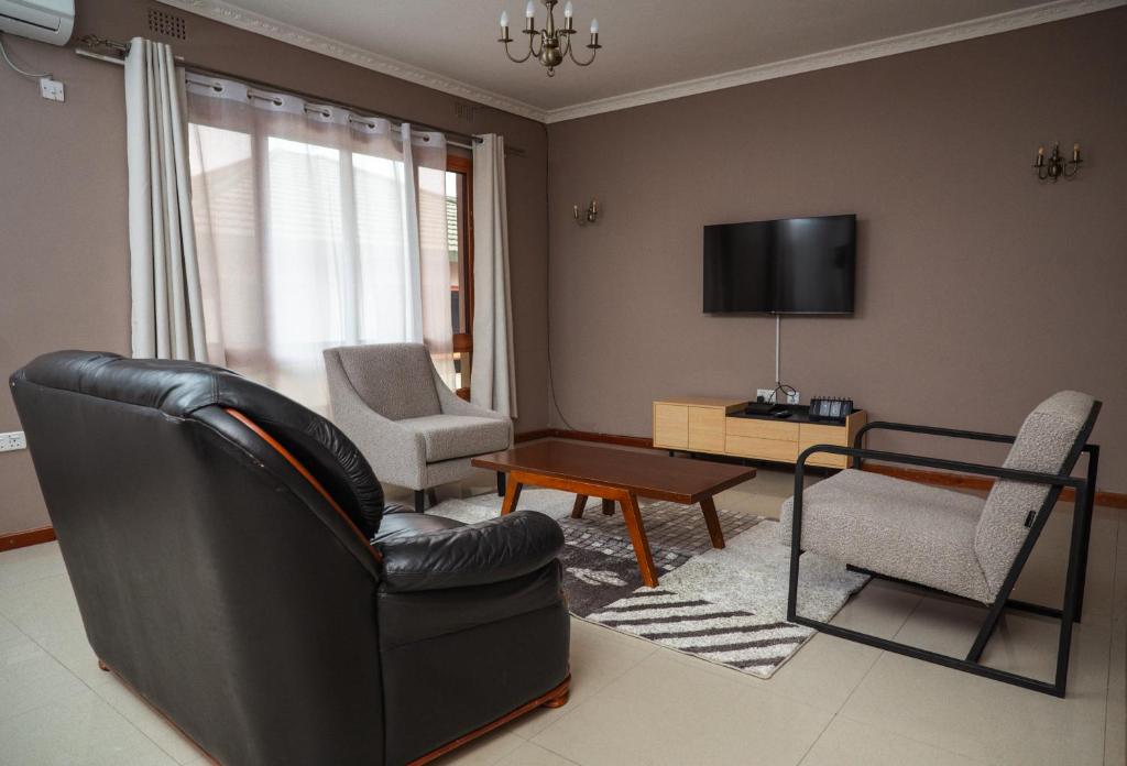 una sala de estar con una silla de cuero negro y una mesa en Niza Homes, Pool, No Blackouts & Walk to Munali Mall, en Lusaka