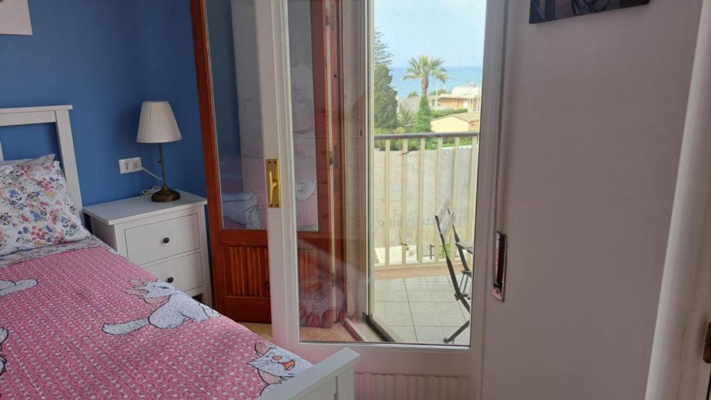 a bedroom with a bed and a view of a balcony at Casa Marie in Marina di Modica