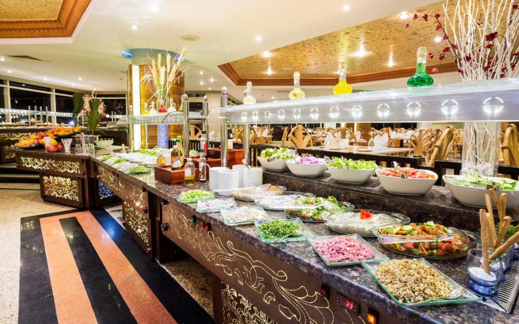 a buffet line with food on display in a restaurant at V Hotel Sharm El Shiekh in Sharm El Sheikh