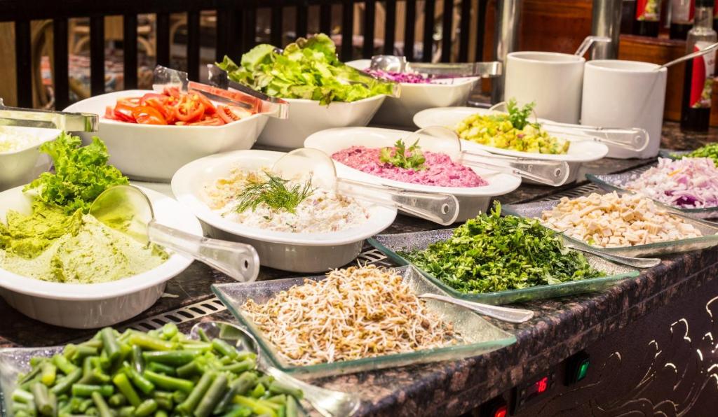 a buffet filled with different types of vegetables on a table at V Hotel Sharm El Shiekh in Sharm El Sheikh