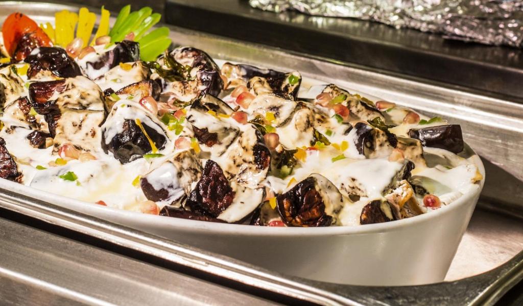 a casserole dish of food with mushrooms and vegetables at V Hotel Sharm El Shiekh in Sharm El Sheikh