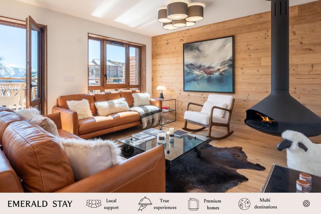 un salon avec un canapé et une cheminée dans l'établissement Apartment Ecrin Alpe d'Huez - BY EMERALD STAY, à Huez