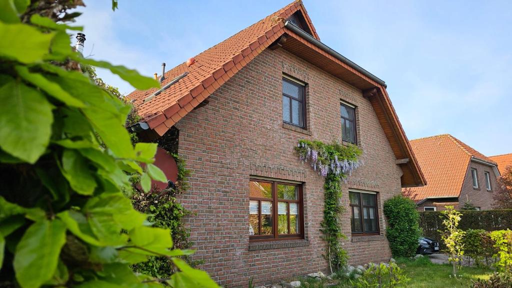 a brown brick house with a red roof at Ferienwohnung "Friesentied" 35229 in Hesel