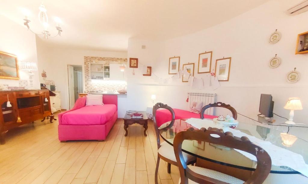 un soggiorno con divano rosa e tavolo di Villa Adelia a Pozzuoli