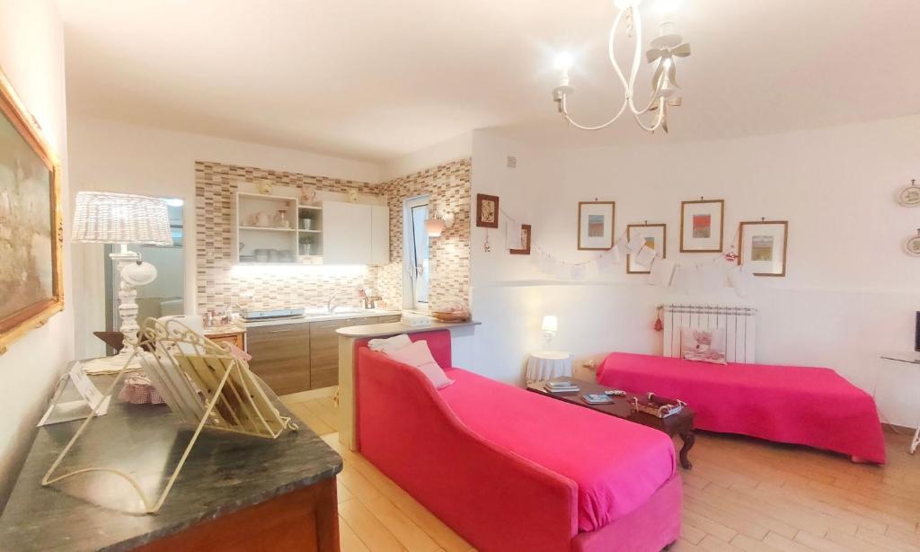 ein Wohnzimmer mit einem roten Sofa und einem Tisch in der Unterkunft Amorevole villa con terrazza e parcheggio privato in Pozzuoli