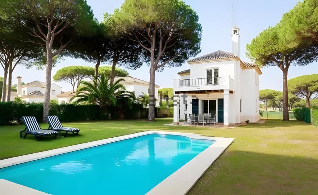 a house with a swimming pool in front of a house at Villa La Cayetana Sancti Petri in Chiclana de la Frontera