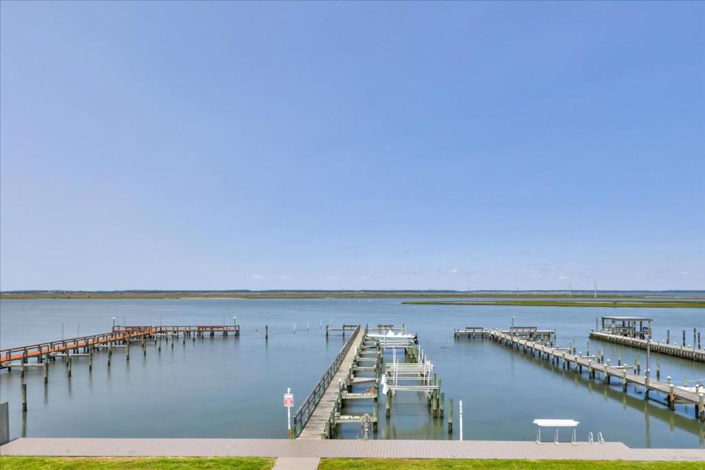 a dock with boats on a large body of water at Water's Edge in Chincoteague