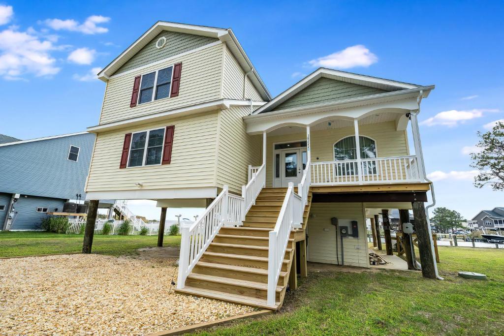 Una casa amarilla con escaleras que conducen a ella. en Casa Del Sol, en Greenbackville