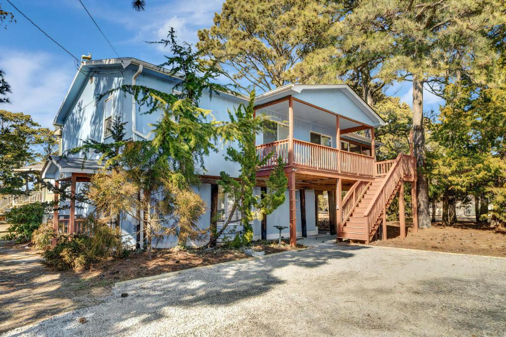 une grande maison bleue avec une terrasse et des escaliers. dans l'établissement Oyster Bay Oasis, à Deep Hole